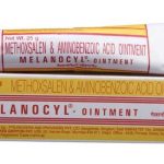 A tube and box of Melanocyl Ointment, containing Methoxsalen and Aminobenzoic Acid. The packaging is primarily white with red and yellow text and design elements.